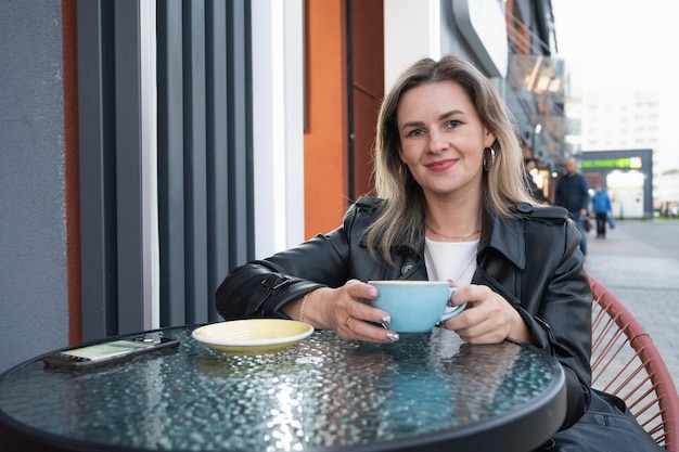 Femme buvant du café dans un café en plein air