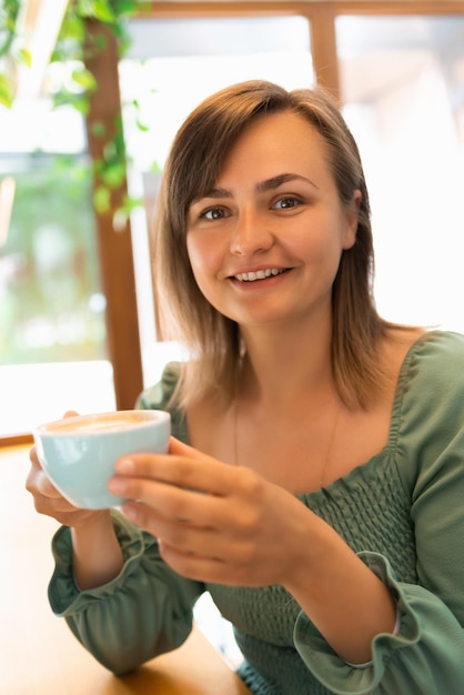 Une femme buvant du café le matin dans un café