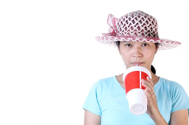 Femme buvant du cola à travers une paille avec verre rouge