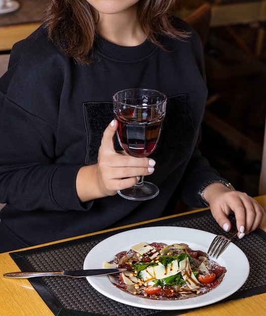 Femme buvant du jus avec salade de poisson