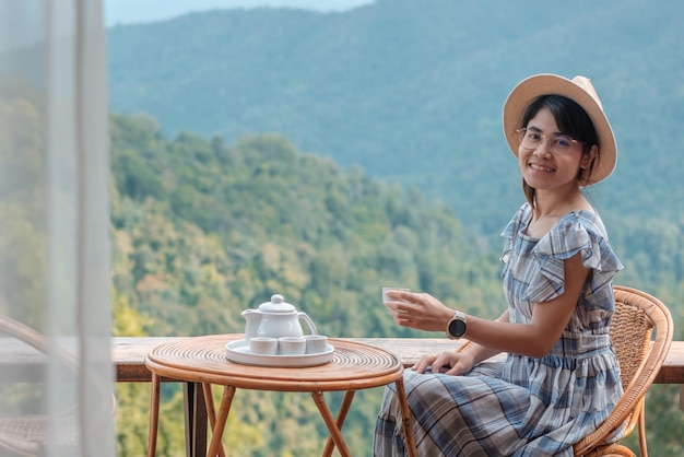 Femme buvant du thé et regardant la montagne vue jeune blogueur séjour à la campagne chez l'habitant le matinVoyage de voyage de vacances et concept de détente