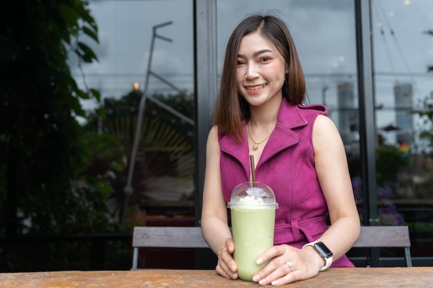 Femme buvant du thé vert frappé au café