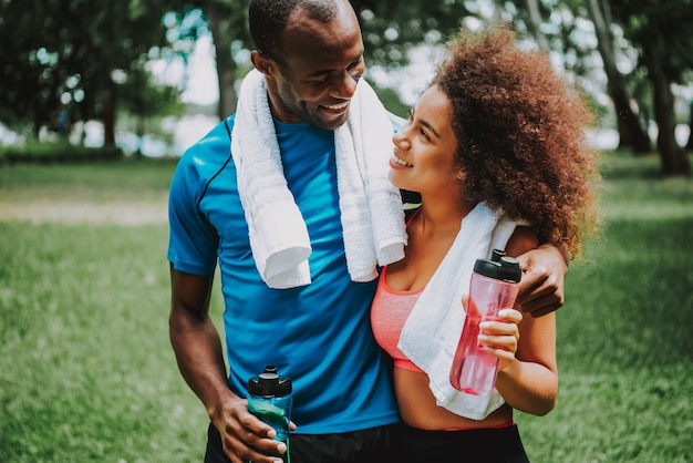 Femme buvant de l&#39;eau après un couple d&#39;exercice ensemble dans un parc