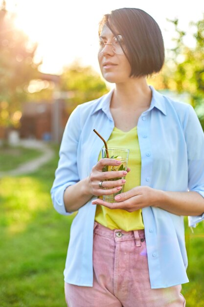 Femme buvant de la limonade aux agrumes d'été avec des pailles métalliques réutilisables