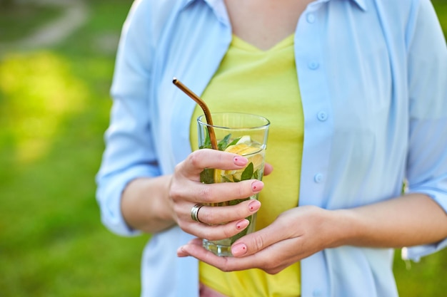 Femme buvant de la limonade aux agrumes d'été avec des pailles métalliques réutilisables