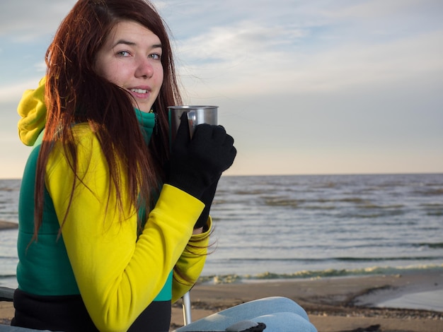 Femme buvant sur la plage