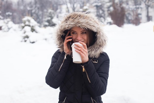 Femme buvant sa boisson chaude dans une tasse. L'hiver.