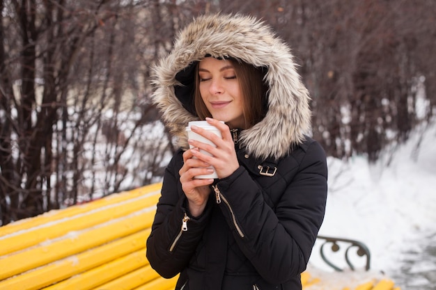 Femme buvant sa boisson chaude de la tasse Saison d'hiver