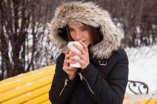 Femme buvant sa boisson chaude de la tasse Saison d'hiver