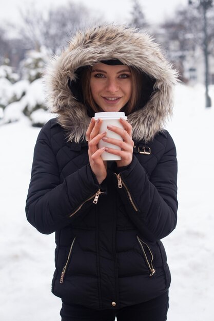 Femme buvant sa boisson chaude thé ou café de la tasse saison d'hiver