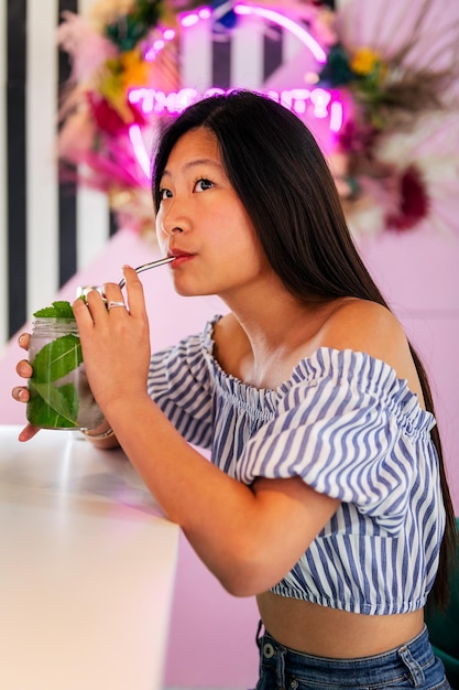 Femme buvant un soda dans un café branché