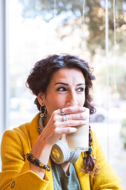 Photo femme buvant un verre de café par une journée ensoleillée