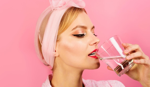 Femme buvant un verre d'eau pure le matin après le réveil perte de poids régime alimentaire sain