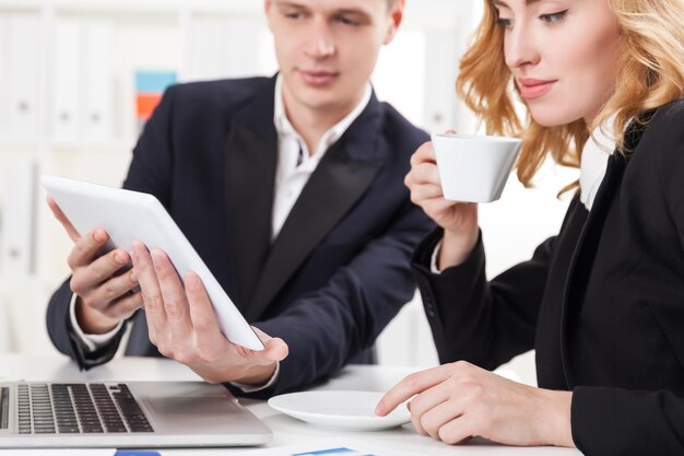 Femme avec café regardant la tablette de l'homme