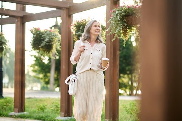 femme, à, café, regarder, fleurs, dans parc