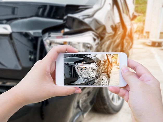 Femme cale mobile smartphone photographie accident de voiture pour l'assurance