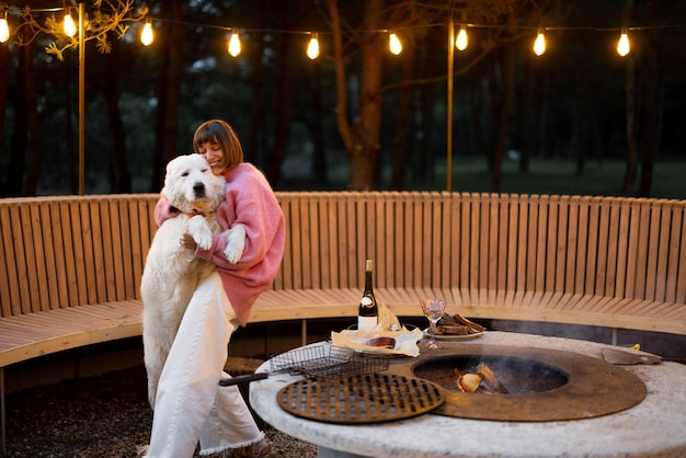 Femme câlins avec son chien au salon barbecue en forêt