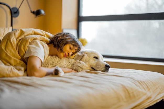 Femme câlins avec son chien mignon au lit