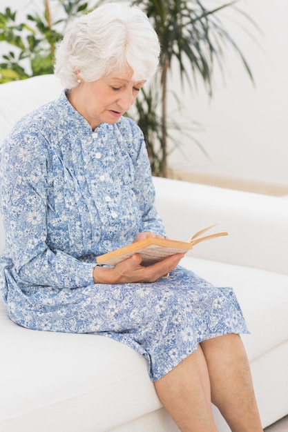 Femme calme âgée lisant un vieux roman