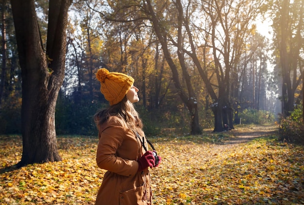 Femme avec caméra au parc d'automne