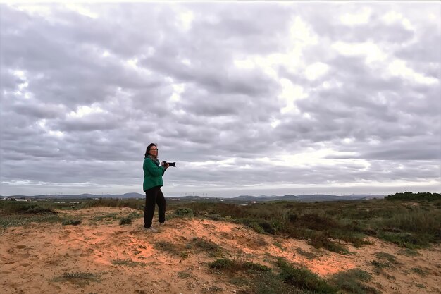 Photo une femme avec une caméra au sommet de la colline