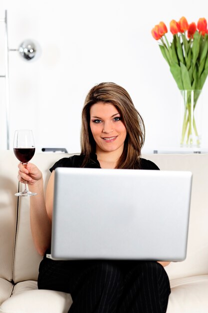 Femme Sur Canapé Avec Ordinateur Et Verre De Vin