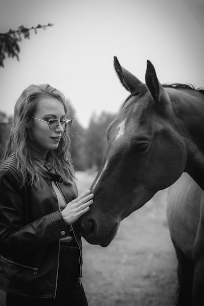 Une femme caressant un cheval dans un champ.