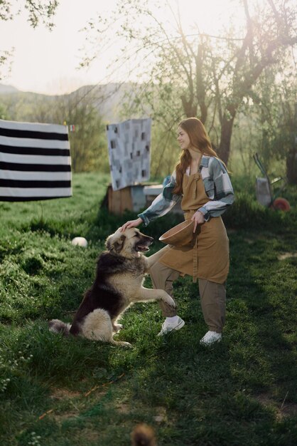 Femme caressant son gros chien poilu à la ferme à la campagne sur fond de linge propre sur une corde