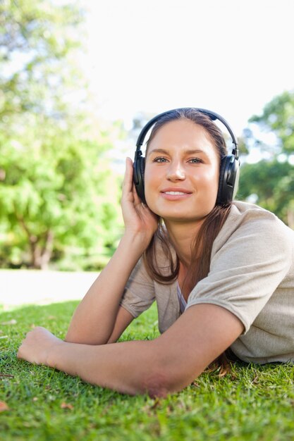 Femme avec un casque allongé sur l&#39;herbe