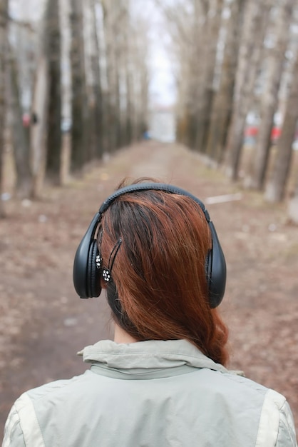 Femme avec un casque à l'automne du parc