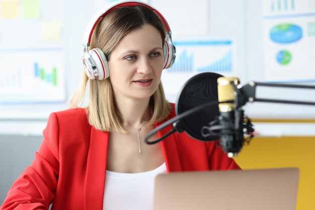 Photo femme avec un casque devant le microphone à la table de travail