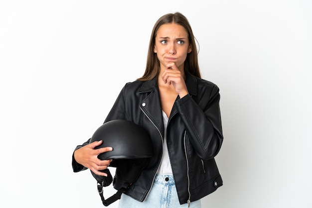 Femme avec un casque de moto isolé ayant des doutes et pensant