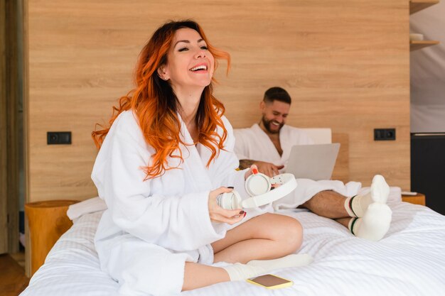 Femme avec un casque rit assis sur le lit