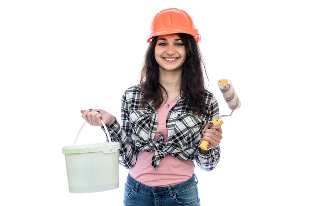 Femme en casque avec seau de peinture isolé sur mur blanc