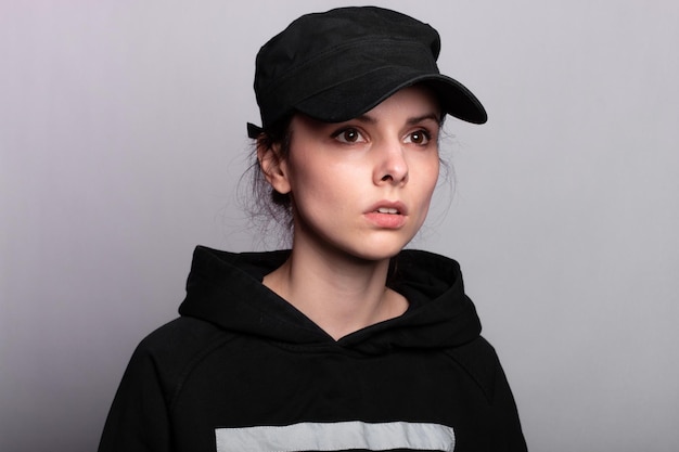 femme avec une casquette noire et un sweat à capuche