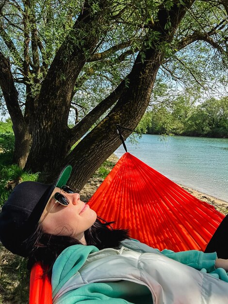 Photo une femme avec une casquette repose dans un hameau surplombant la rivière.