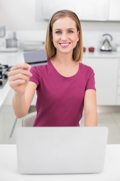 Femme casual blonde avec ordinateur portable et carte de crédit