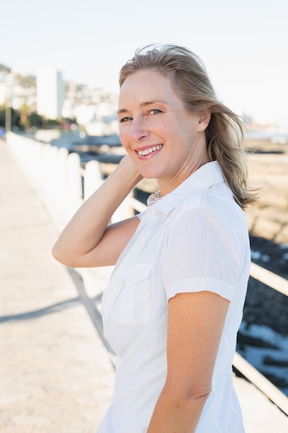 Femme Casual souriant à la caméra au bord de la mer