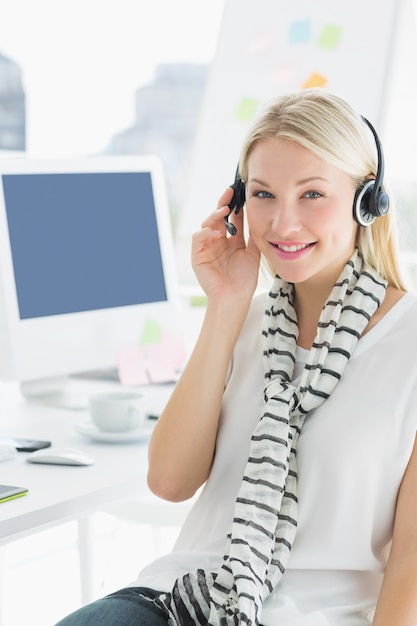 Femme casual souriante avec casque dans le bureau