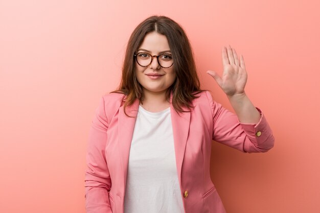 Femme caucasien de taille plus jeune entreprise souriant sourire montrant le numéro cinq avec les doigts.