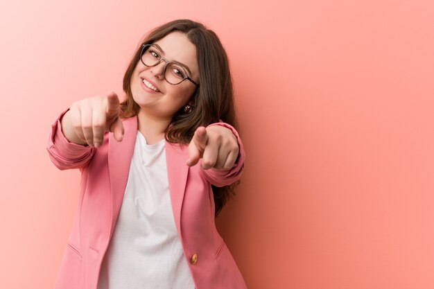 Femme caucasien de taille plus jeune entreprise souriante enjouée pointant.