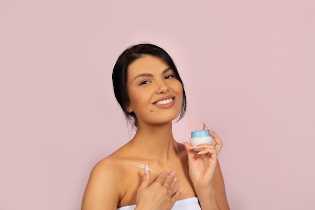 Femme caucasienne d'âge moyen avec un produit de soin de beauté