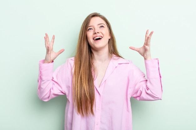 Femme caucasienne aux cheveux roux hurlant furieusement, se sentant stressée et agacée avec les mains en l'air disant pourquoi moi