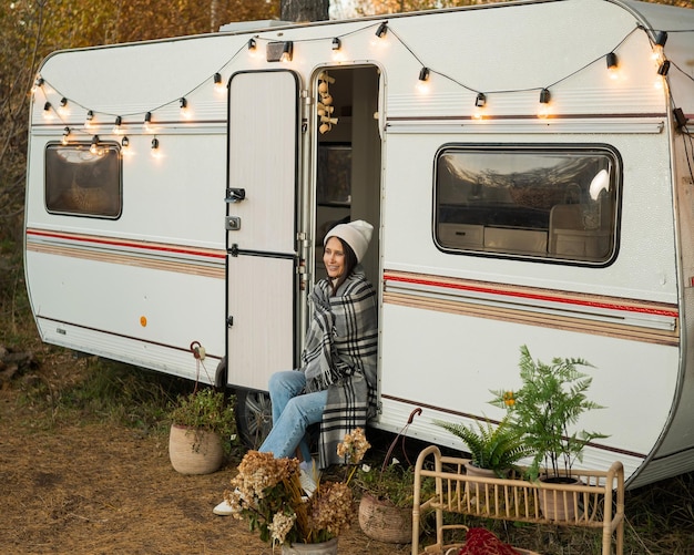 Photo une femme caucasienne est assise dans une fourgonnette lors d'un voyage d'automne chaud dans un camping-car