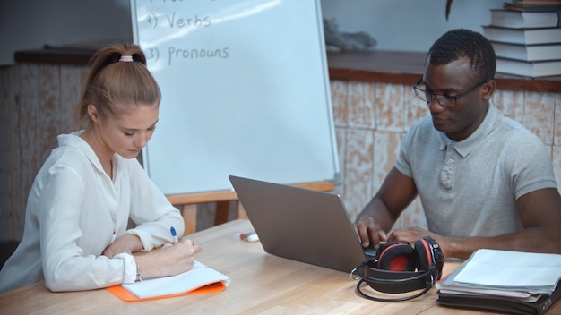 Femme caucasienne et homme afro-américain ayant un cours d'anglais