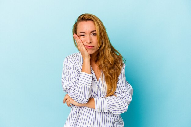 Femme caucasienne isolée sur fond bleu qui s'ennuie, est fatiguée et a besoin d'une journée de détente.