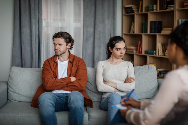 Une femme caucasienne millénaire en colère ignore l'homme en consultation avec un psychologue à l'intérieur de la clinique