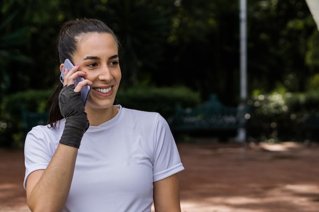 Femme caucasienne parlant au téléphone dans un parc avec espace de copie.