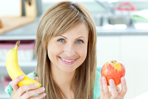 Femme caucasienne positive, holing, a, banane, et, pomme, dans cuisine