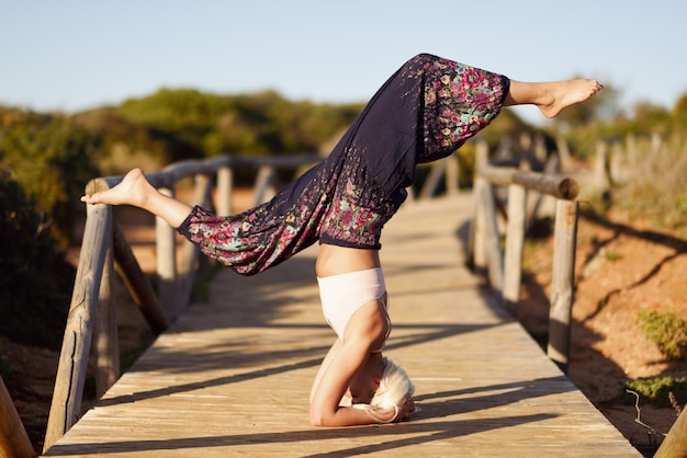 Femme caucasienne, pratiquer l&#39;yoga sur un pont en bois.